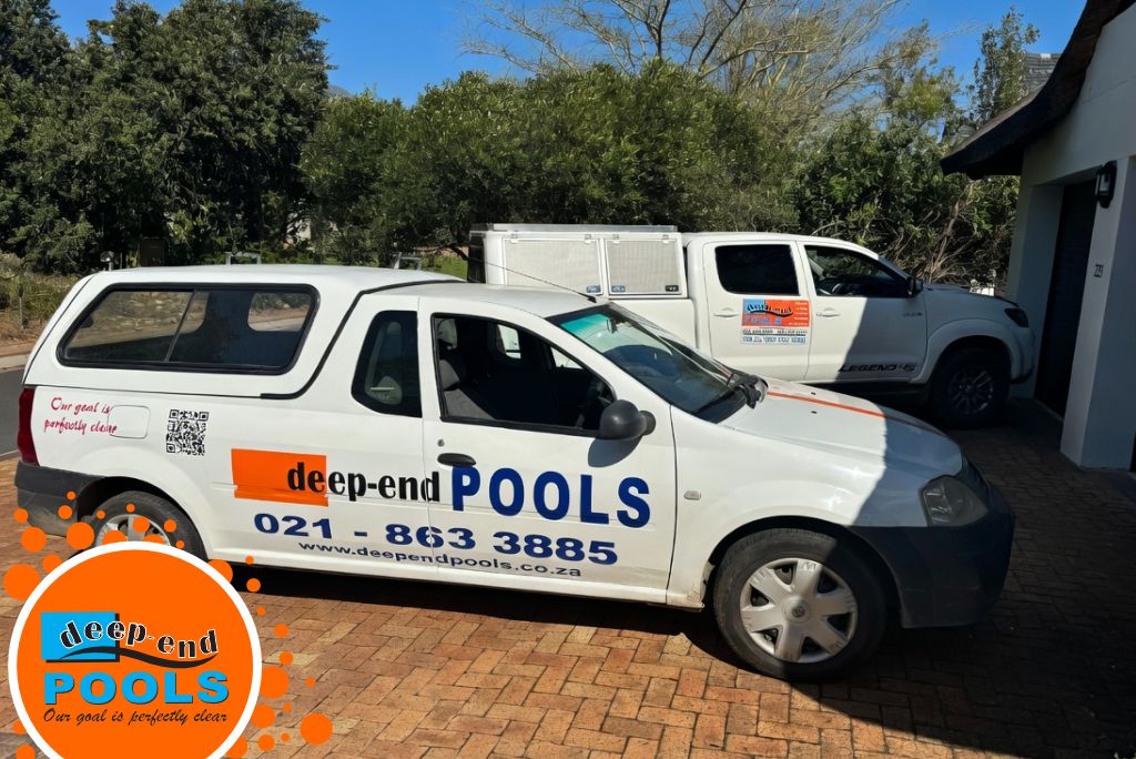 Deep-End-Pools-Company-Vehicles-Wellington Deep End Pools company vehicles parked outside a property — white bakkie with full branding and a white pickup truck with canopy. Professional pool service vehicles in the Cape Winelands area.