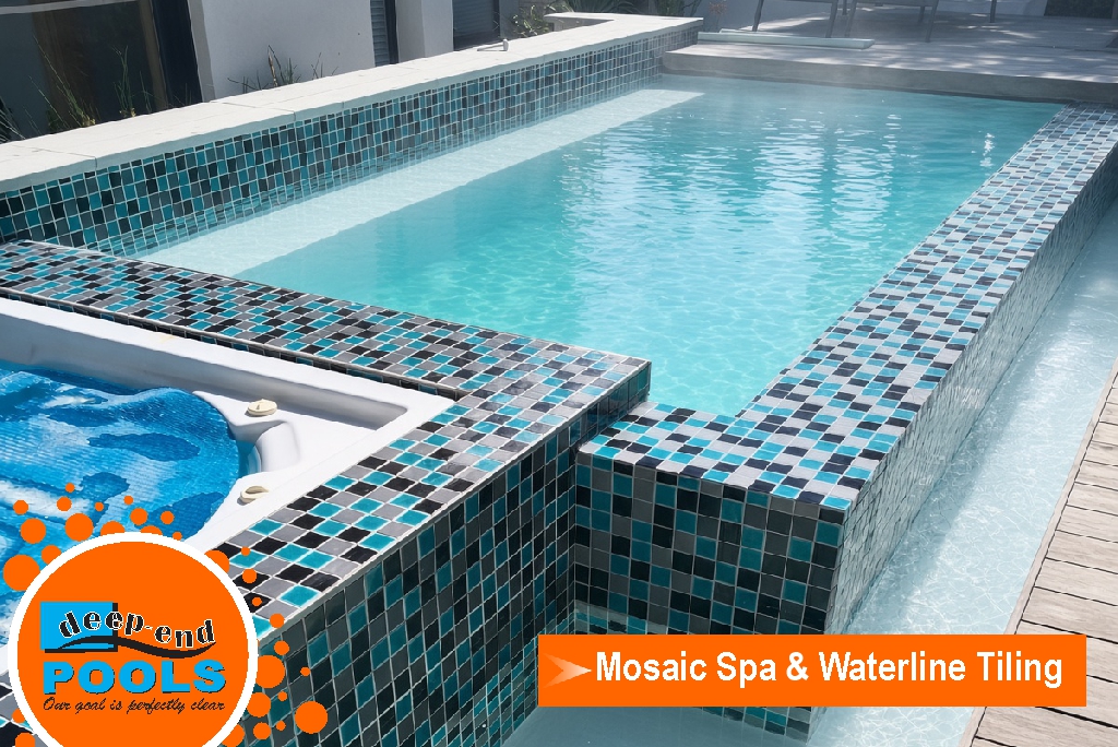 deep-end-pools-mosaic-spa-waterline-teal-black-silver Raised spa with teal, black and silver glass mosaic on the walls and waterline, beside a swimming pool, finished by Deep End Pools.
